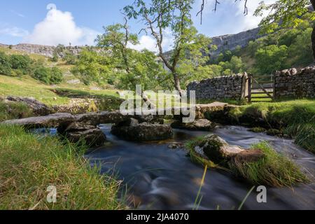 Improvvisato ponte di pietra sul torrente che scorre fuori di Malham Cove nel Yorkshire Dales. Visitata durante la passeggiata lungo la Dales High Way. Foto Stock