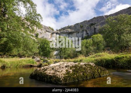 Una lunga esposizione dal centro del torrente Malham Cove, guardando verso le imponenti scogliere calcaree della famosa Cove. Yorkshire Dales. Foto Stock