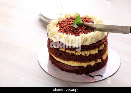 Torta di velluto rosso affettabile, torta classica a tre strati di dolci di spugna al burro rosso con crema di formaggio glassato, cucina americana Foto Stock