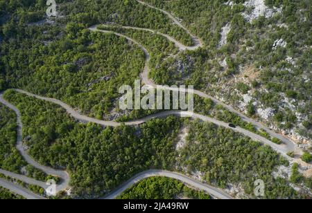 Vista sul drone di una strada a serpentina di montagna in Montenegro. Foto Stock
