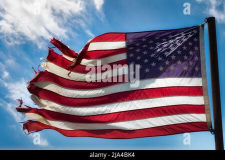 Una bandiera americana attutita ondeggia nel vento vicino a Fabens rurale, Texas, appena ad est di El Paso. Foto Stock