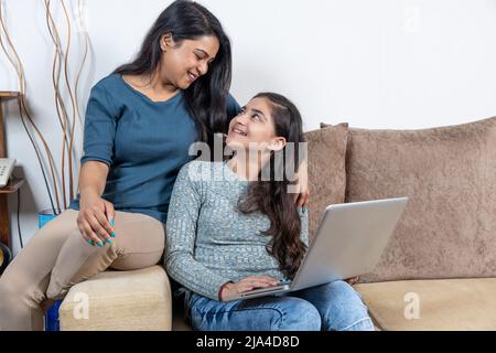 Felice madre e figlia che guarda il notebook Foto Stock