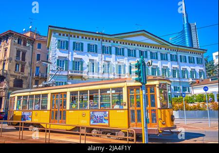 MILANO, ITALIA - 5 APRILE 2022: Il tram retrò giallo percorre la strada nel quartiere porta Nuova, il 5 aprile a Milano Foto Stock