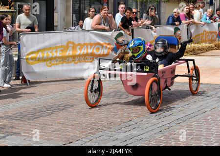 Prima edizione di una gara di soapbox nel cuore del centro della città di Crépy-en-Valois. Una scatola di sapone fatta in casa che precipita lungo il pendio della strada principale. Foto Stock