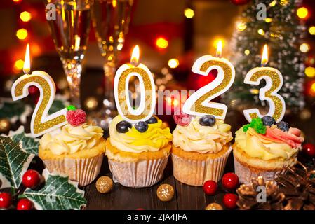 Vassoio con cupcakes candele di nuovo anno e wineglasses Foto Stock