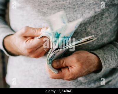 Le mani di conteggio di rubli russi. Messa a fuoco selettiva. DOF poco profondo Foto Stock