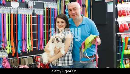 Coppia di famiglia gioiosa con cane scelta nuova ciotola Foto Stock