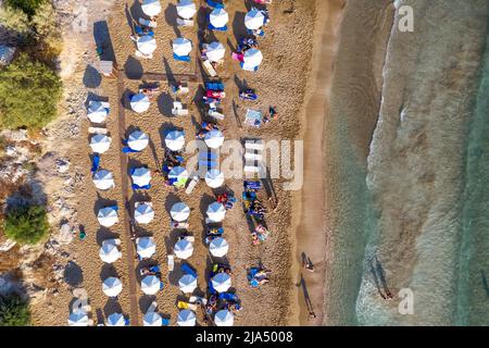 La gente gode di una bella giornata estiva alla spiaggia di Coral Bay. Peyia villaggio, distretto di Paphos, Cipro Foto Stock