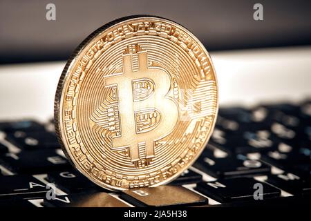 Moneta criptovaluta bitcoin giace sulla tastiera sfondo tema piramide di scambio oro per denaro a causa di aumento o diminuzione tasso di cambio primo piano Foto Stock