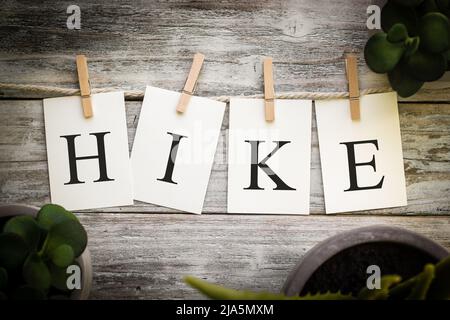 Un insieme di schede stampate che ortografia la parola ESCURSIONE su un vecchio sfondo di legno. Foto Stock