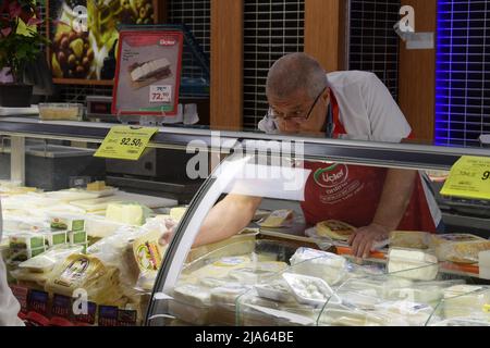 Istanbul, Turchia. 26th maggio 2022. Il 26 maggio 2022 un addetto al banco formaggi organizza i prodotti lattiero-caseari in un supermercato di Istanbul, Turchia. Un supermercato a Istanbul, un tempo affollato di acquirenti di una grande varietà di merci, è ora completamente desolato, poiché l'inflazione ha spinto i prezzi fuori portata. PER ANDARE CON 'caratteristica: Supermercato turco deserted in mezzo sempre crescente cibo prezzi' Credit: Shadati/Xinhua/Alamy Live News Foto Stock