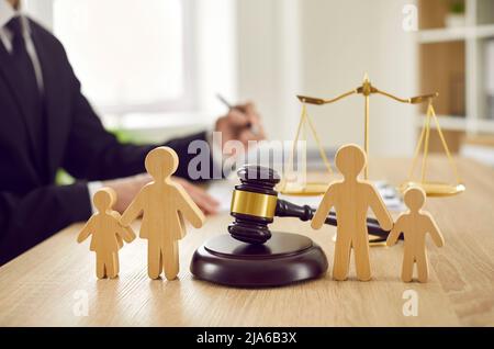 Gavel e le figure della famiglia sul tavolo del giudice che illustrano il concetto di divorzio e custodia del bambino Foto Stock