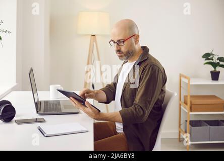 Il freelance caucasico lavora online su gadget Foto Stock