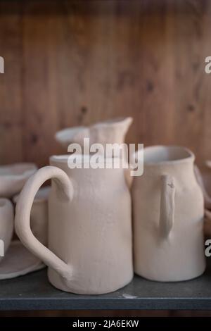 Piatti in ceramica pronti, caraffe fatte a mano su una mensola o vetrina. Foto Stock