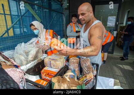 Maschi che raccolgono cibo dalla banca alimentare locale nel sud-ovest di Londra , Inghilterra Foto Stock