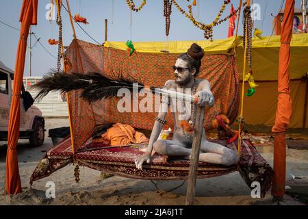 Prayagraj, Uttar Pradesh, India. 2nd Feb 2019. Un sadhu naga siede sul suo swing durante il festival di Kumbh Mela. Ogni dodici anni, milioni di devoti indù iniziano un massiccio pellegrinaggio verso il più sacro dei festival indiani: Il Kumbha Mela, che si svolge a Prayagraj, un luogo considerato particolarmente propizio perché è alla confluenza del Gange, Yamuna e il mitico Saraswati. Si stima che nel 2019 120 milioni di persone hanno partecipato alla sacra recinzione nel corso di un mese e mezzo. Questi numeri, equivalenti alla popolazione totale del Giappone, e 40 volte il numero Foto Stock