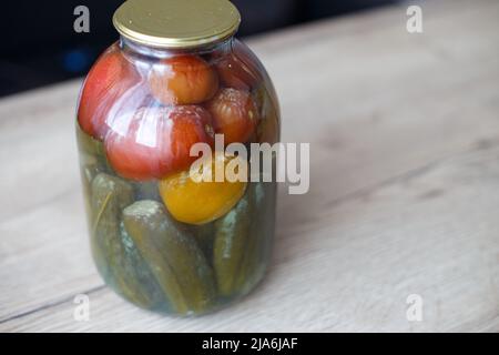 lattina viziata di aggraffatura vegetale. Vaso in vetro con pomodori e cetrioli fatti in casa sottaceto con funghi bianchi e muffa Foto Stock