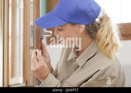 costruttore femmina che fissa il finestrino Foto Stock
