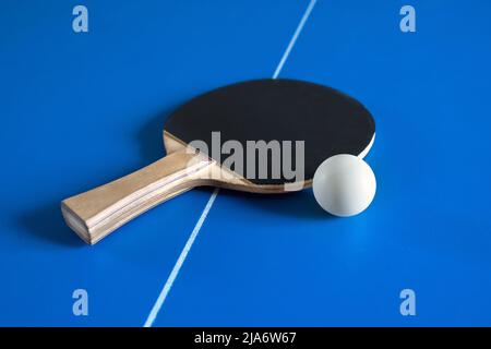 Una racchetta da tennis e una palla sul tavolo. Un gioco di sport. Foto Stock