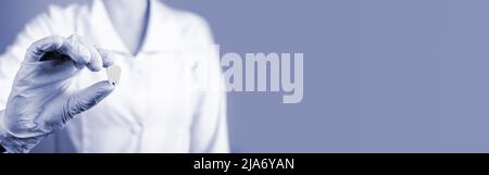 Striscione con medico che tiene il dente bianco. Impianto, igiene orale, stomatologia, carie e prevenzione delle malattie periodontali, concetto di cura dentale. Spazio di copia. Foto di alta qualità Foto Stock