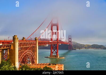 Nebbia che copre la cima del Golden Gate Bridge a San Francisco con colori vivaci Foto Stock