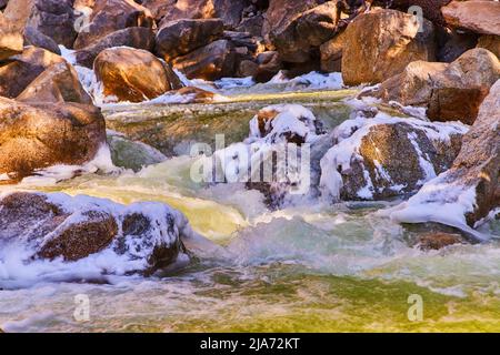 Fiume veloce e pericoloso a cascata su rocce ghiacciate Foto Stock