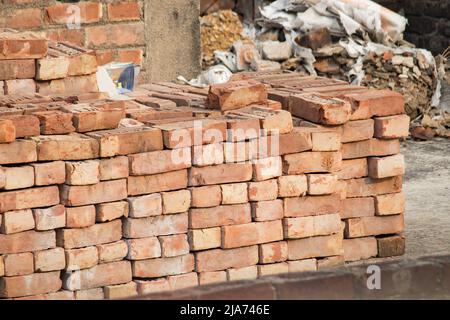 Mattoni accatastati insieme per costruzione in area urbana indiana. Foto Stock
