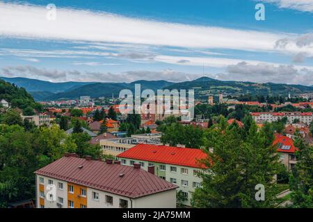 Banska Bystrica, Slovacchia – 17 agosto 2021: Paesaggio urbano estivo aereo – edifici colorati, verdi colline all'orizzonte e cielo blu Foto Stock