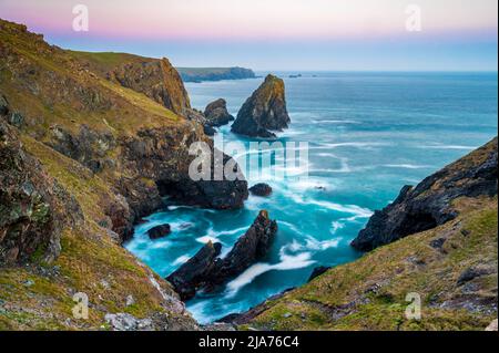 La costa della Cornovaglia, Inghilterra. Una serata estiva e il cielo splendente mentre il sole tramonta sulla spettacolare e frastagliata costa Foto Stock