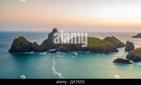 La costa della Cornovaglia, Inghilterra. Una serata estiva e il cielo splendente mentre il sole tramonta sulla spettacolare e frastagliata costa Foto Stock