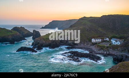 Kynance Cove, Cornovaglia, Inghilterra. Una serata estiva e il cielo splendente mentre il sole tramonta sulla spettacolare e frastagliata costa Foto Stock