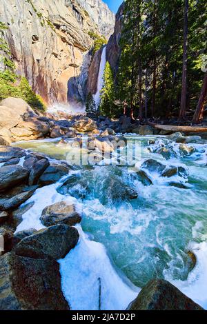Cascate di ghiaccio cade su passeggiate gelide con arcobaleno accanto alle Lower Yosemite Falls Foto Stock