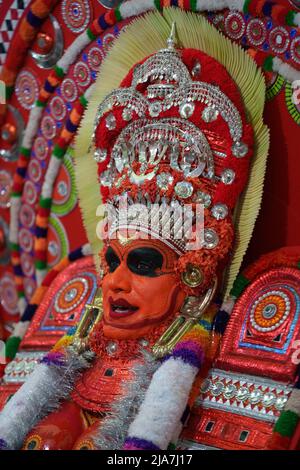 Theyyam è una famosa forma d'arte rituale in kerala con il volto dipinto utilizzando colori organici e l'uso di strumenti musicali come Chenda, Elathalam, , Kurumkuzal Foto Stock