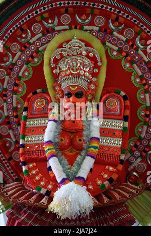 Theyyam è una famosa forma d'arte rituale in kerala con il volto dipinto utilizzando colori organici e l'uso di strumenti musicali come Chenda, Elathalam, Kurumkuzal Foto Stock