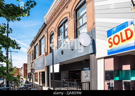 Tradizionali edifici americani in mattoni con ristoranti e negozi al piano terra lungo un marciapiede in un quartiere storico del centro Foto Stock