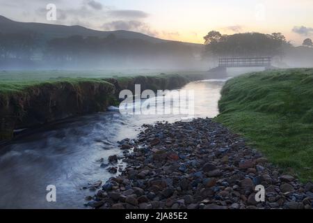 Alba e nebbia mattutina su Gayle Beck vicino alla pittoresca città mercato di Hawes nel Parco Nazionale Yorkshire Dales, Yorkshire, Inghilterra. Foto Stock