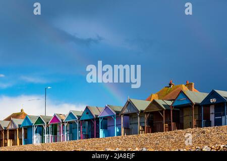 Un arcobaleno visto sopra una fila di capanne tradizionali britanniche della spiaggia, una posizione recente vista nell'imminente dramma teen romantico di Netflix 'Heartstopper'. Foto Stock