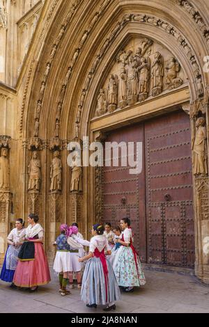 Giovani con costumi regionali davanti alla porta della cattedrale della città di Valencia, in Spagna. Foto Stock