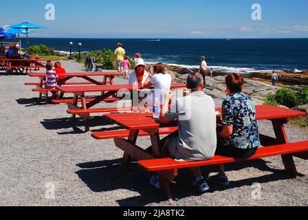 La gente gode di una vista della costa rocciosa del Maine con pranzo al sacco in una giornata estiva soleggiata Foto Stock