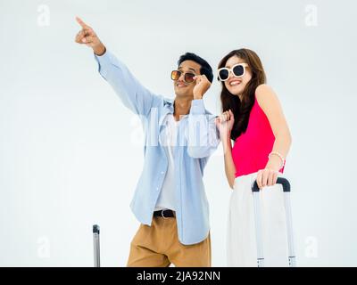 Pronto a viaggiare, buona vacanza. Vacanze estive. Coppia asiatica in occhiali da sole con puntamento e guardando avanti con emozionante, giovane donna e uomo con Foto Stock