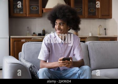 Allegro happy gen Z cellulare utente ragazzo tenere cellulare Foto Stock