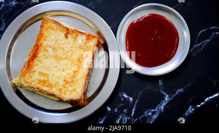 Pane appena cucinato Omelet e salsa di pomodoro rosso sono posti su un piatto d'argento con fondo nero e pronti per servire Foto Stock