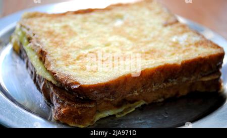 Shot zoomato di una frittata di pane appena fatta tenuta su un piatto d'argento e pronta per servire Foto Stock