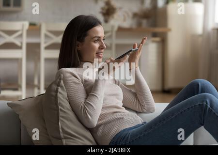 Felice fidanzata ragazza millennial utilizzando l'app Internet, Voice Virtual Assistant Foto Stock