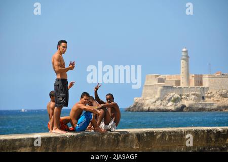 Giovani cubani al Malecon, lungomare nella città vecchia di l'Avana, Cuba, Caraibi Foto Stock