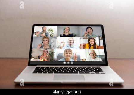 Webcam con schermo per computer portatile per visualizzare diverse etnicità ed età persone impegnate in videoconferenze di gruppo. Videoconferenza. Tecnologia moderna, pratica e pratica on-line Foto Stock