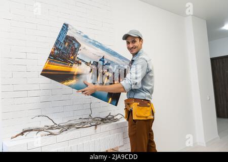 il padrone del riparatore tiene una tela della foto Foto Stock