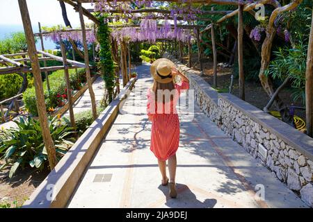 Donna elegante discesa turistica sentiero giardino di Capri, Napoli, Italia Foto Stock