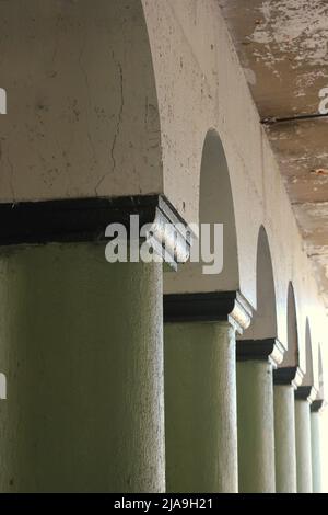 Colonnato industriale della città interna di colonne in cemento che reggono un ponte. Foto Stock