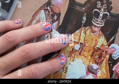 Donna con le unghie dipinte con la bandiera britannica poggiata sulla rivista OK con una foto dell'incoronazione della Regina. Platinum Jubilee 2022 giugno Foto Stock